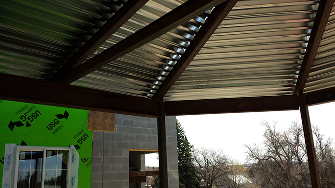 Homestead 4 steel canopy with roof deck and masonry wall behind