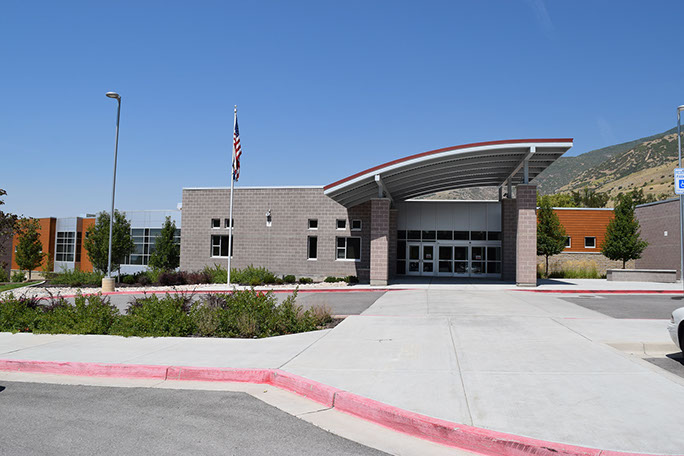 Vista Education Campus entrance canopy and parking lot with flag pole