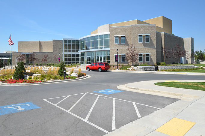 Davis Center for the Performing Arts exterior from parking lot with landscaping and flag